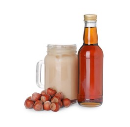 Photo of Mason jar of delicious iced coffee, syrup and hazelnuts isolated on white