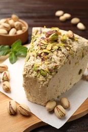 Photo of Piece of tasty halva with pistachios on table, closeup