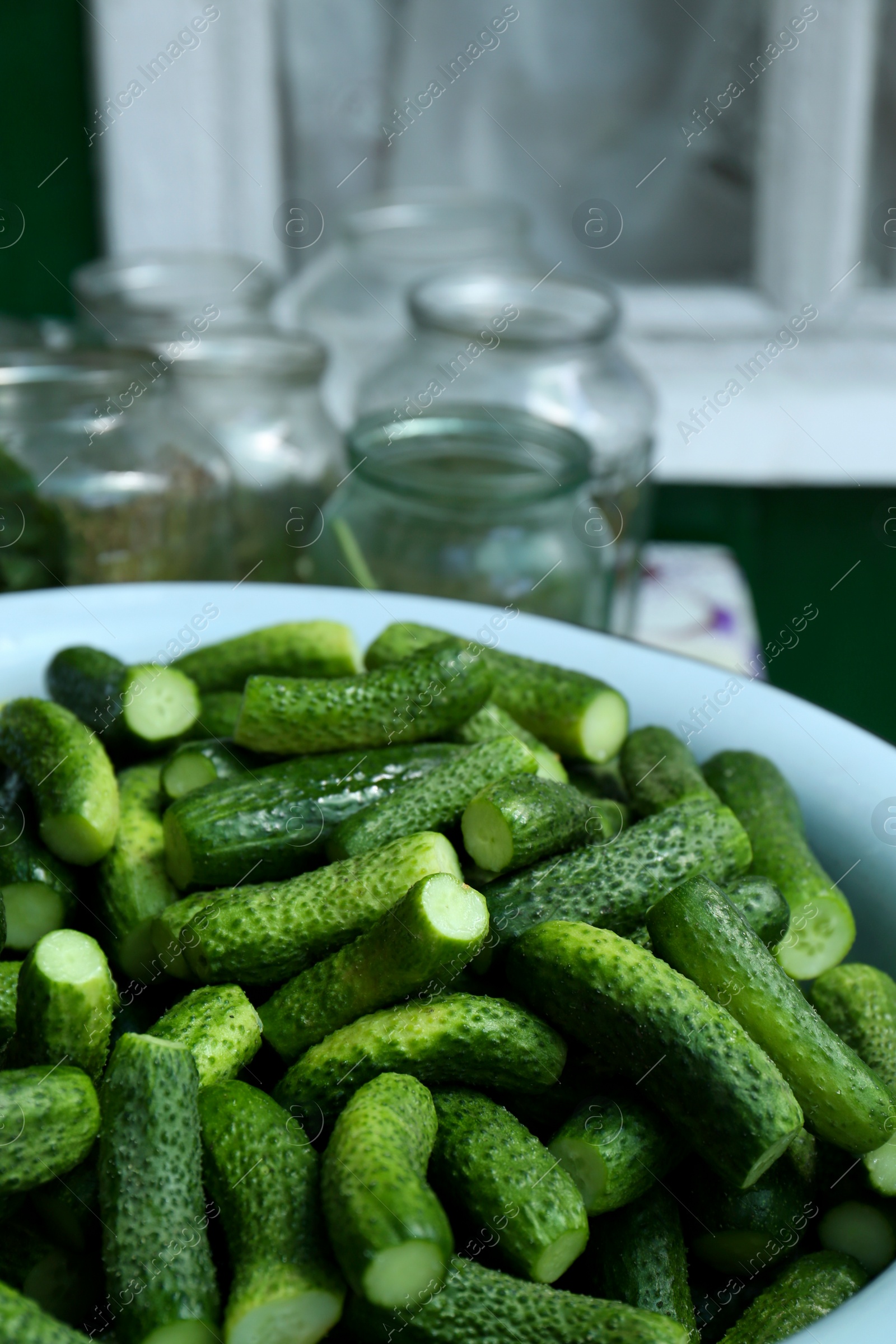 Photo of Fresh ripe cucumbers in metal bowl, closeup. Pickling vegetables