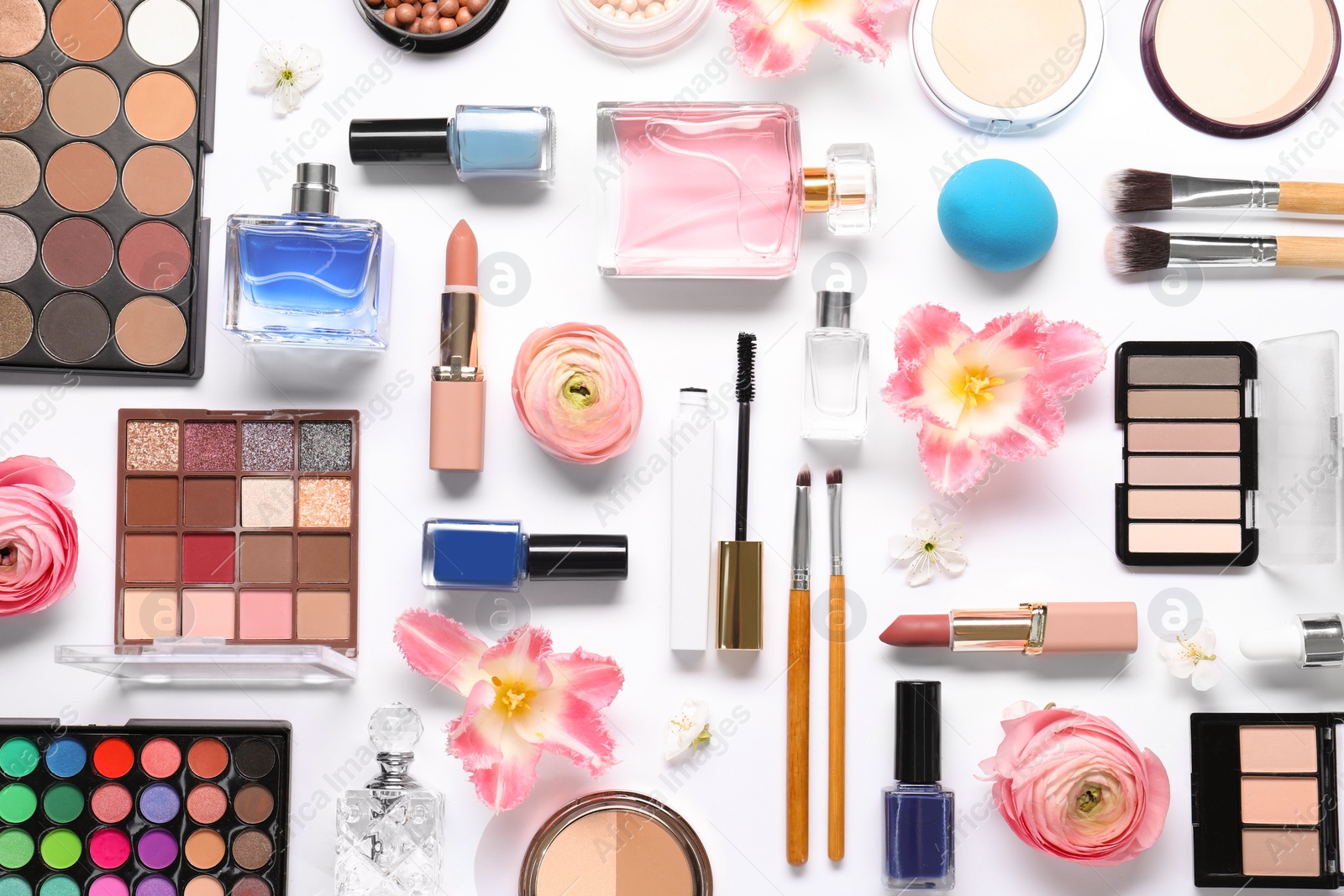 Photo of Flat lay composition with different makeup products and beautiful spring flowers on white background