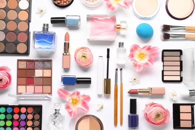 Photo of Flat lay composition with different makeup products and beautiful spring flowers on white background