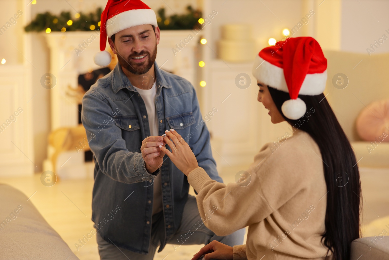 Photo of Man with engagement ring making proposal to his girlfriend at home on Christmas