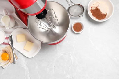 Red stand mixer and different ingredients on light grey marble table, flat lay. Space for text