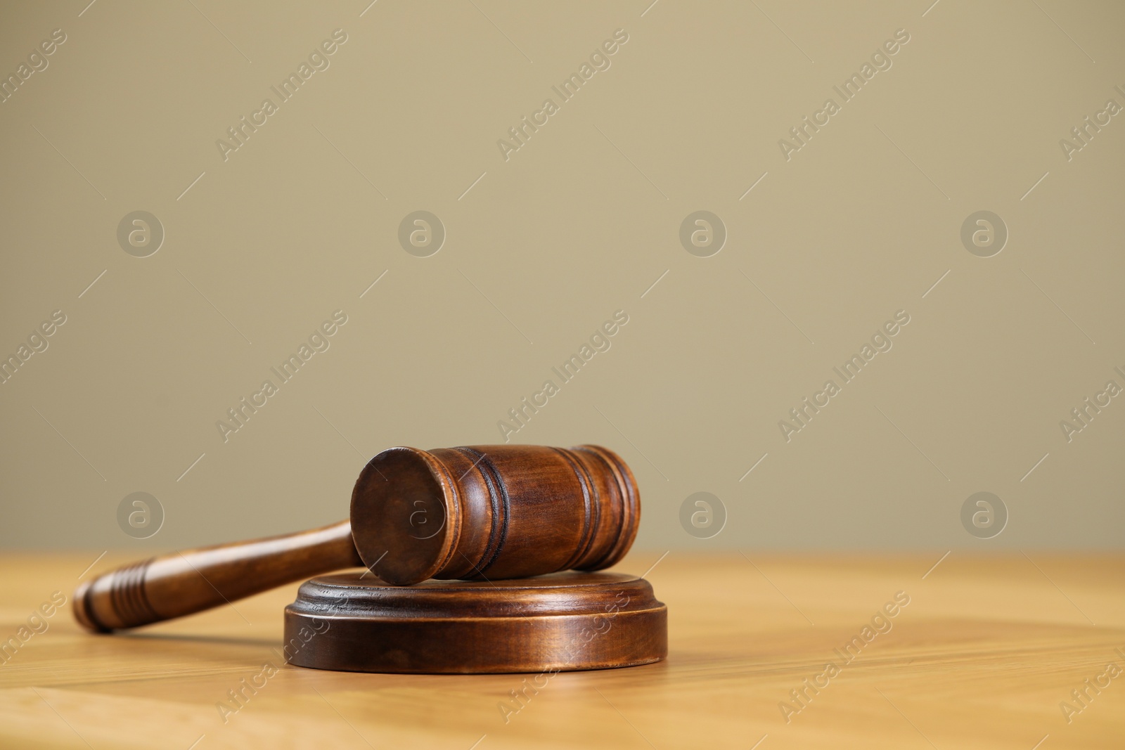 Photo of Wooden gavel on table against beige background. Space for text