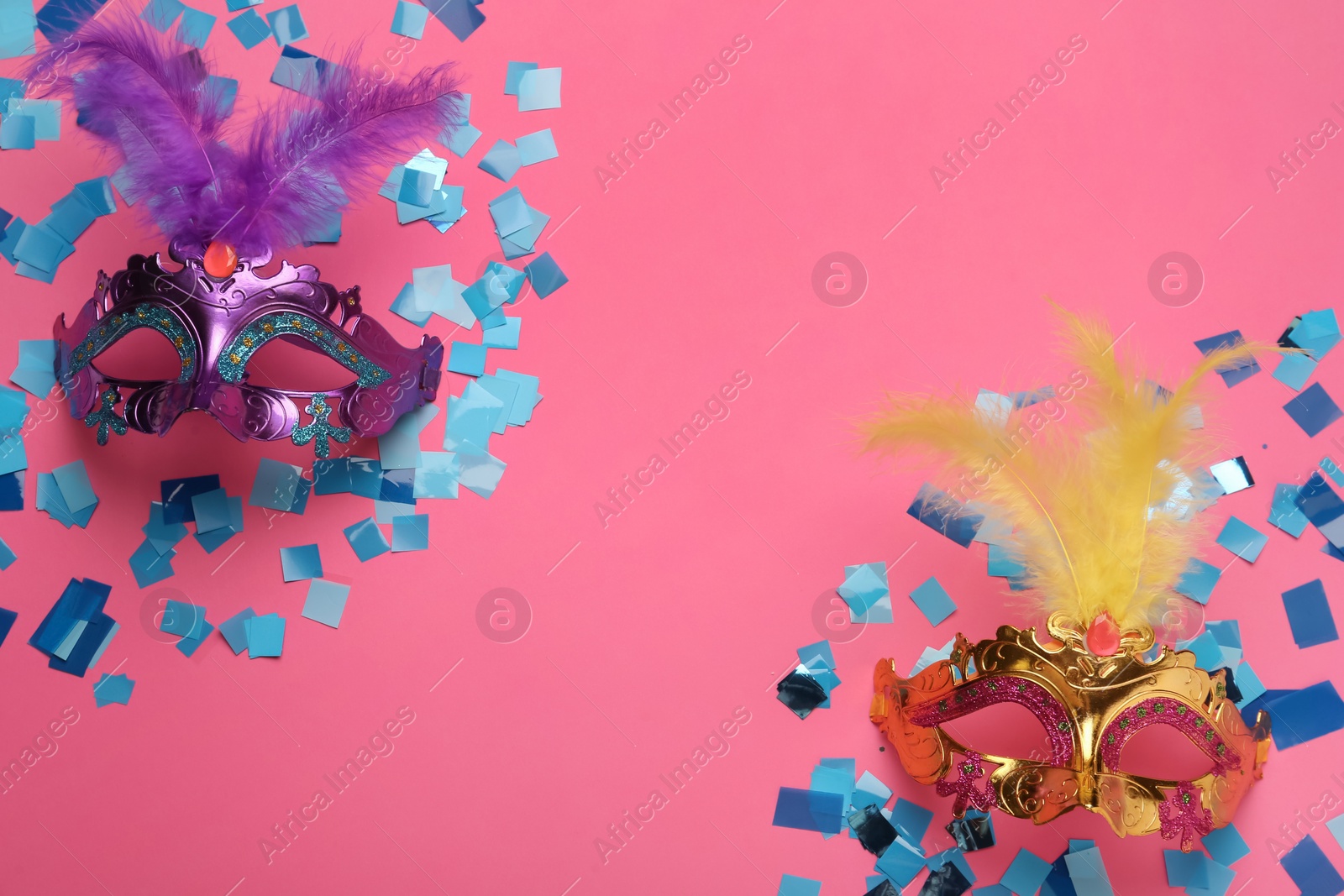 Photo of Beautiful carnival masks and shiny confetti on pink background, flat lay. Space for text