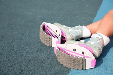 Photo of Woman with kangoo jumping boots on color textured background, closeup. Space for text