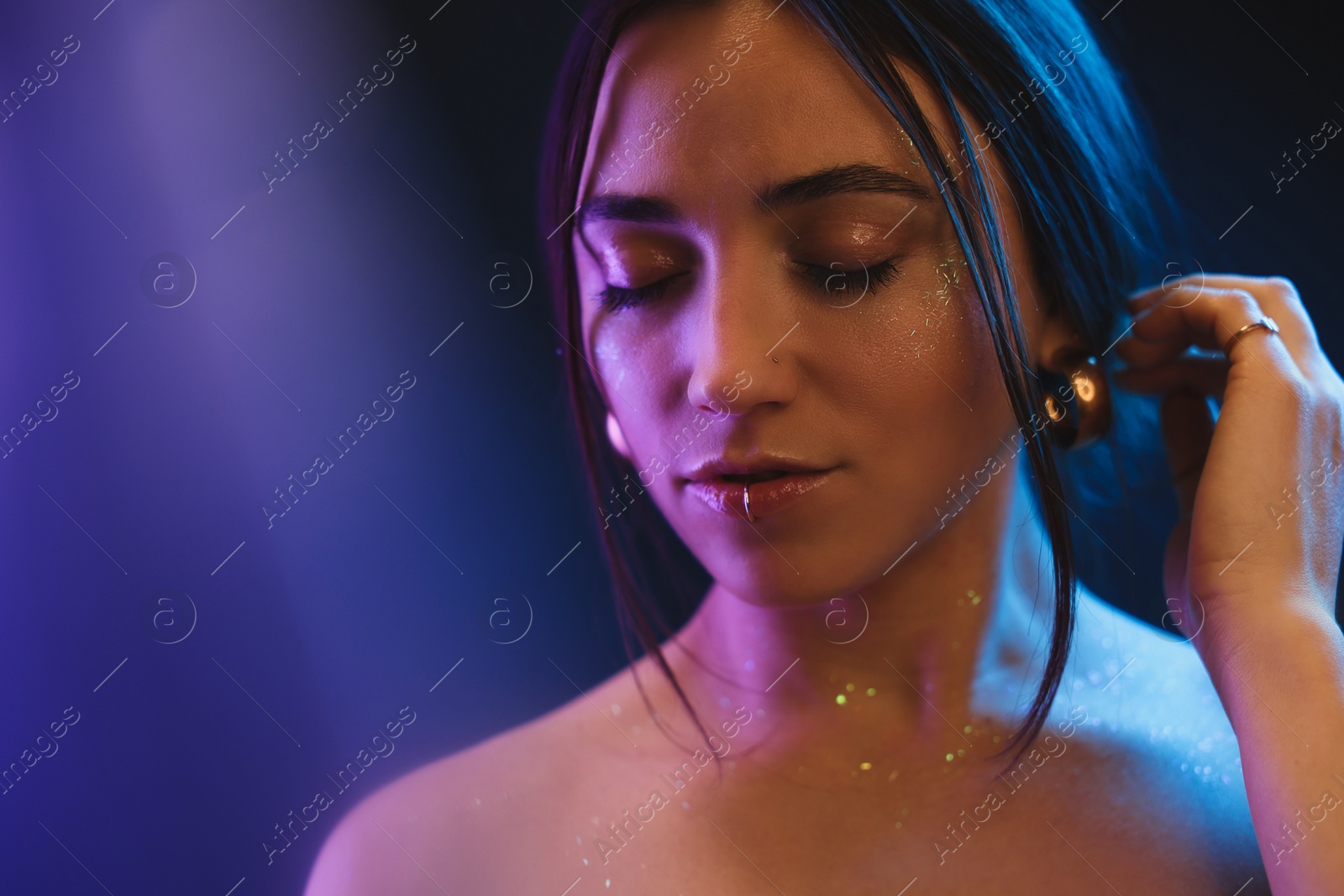 Photo of Portrait of beautiful woman on dark background in neon lights, space for text