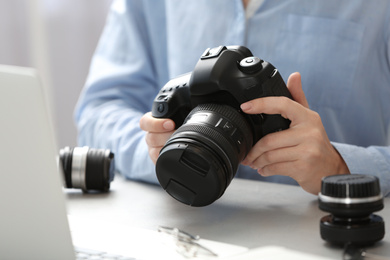 Journalist with camera working at table, closeup