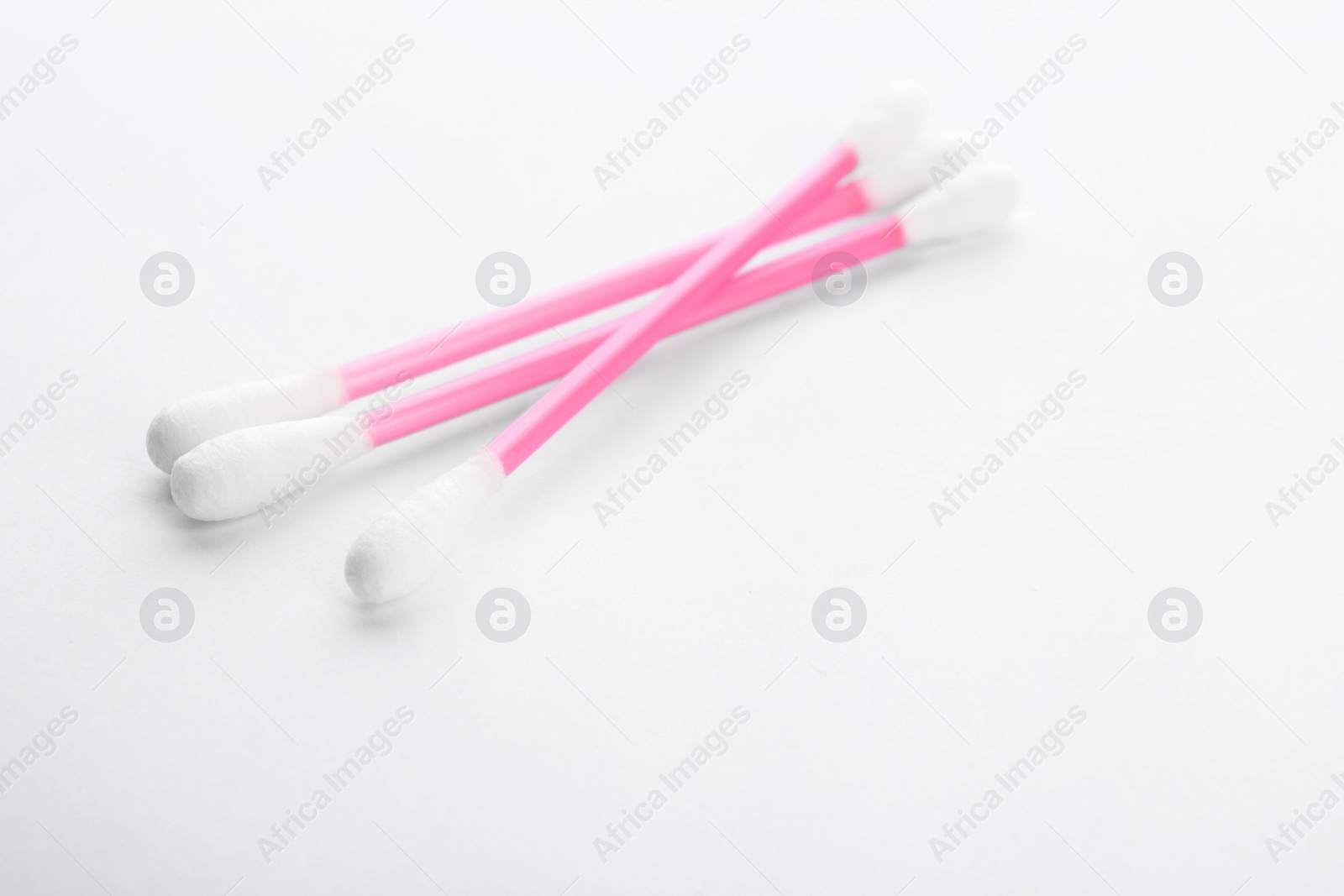 Photo of Pink plastic cotton swabs on white background