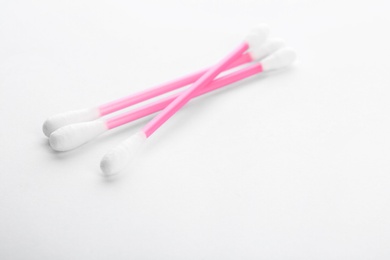Photo of Pink plastic cotton swabs on white background
