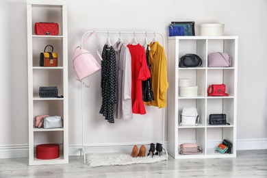 Photo of Wardrobe with stylish bags and clothes indoors. Idea for interior design