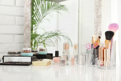 Luxury makeup products and accessories on dressing table with mirror. Space for text