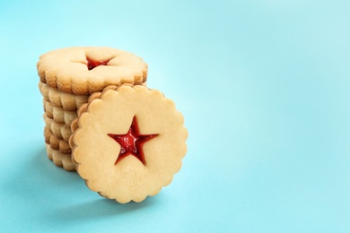 Photo of Traditional Christmas Linzer cookies with sweet jam on color background
