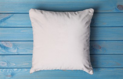 Photo of Blank soft pillow on light blue wooden background, top view
