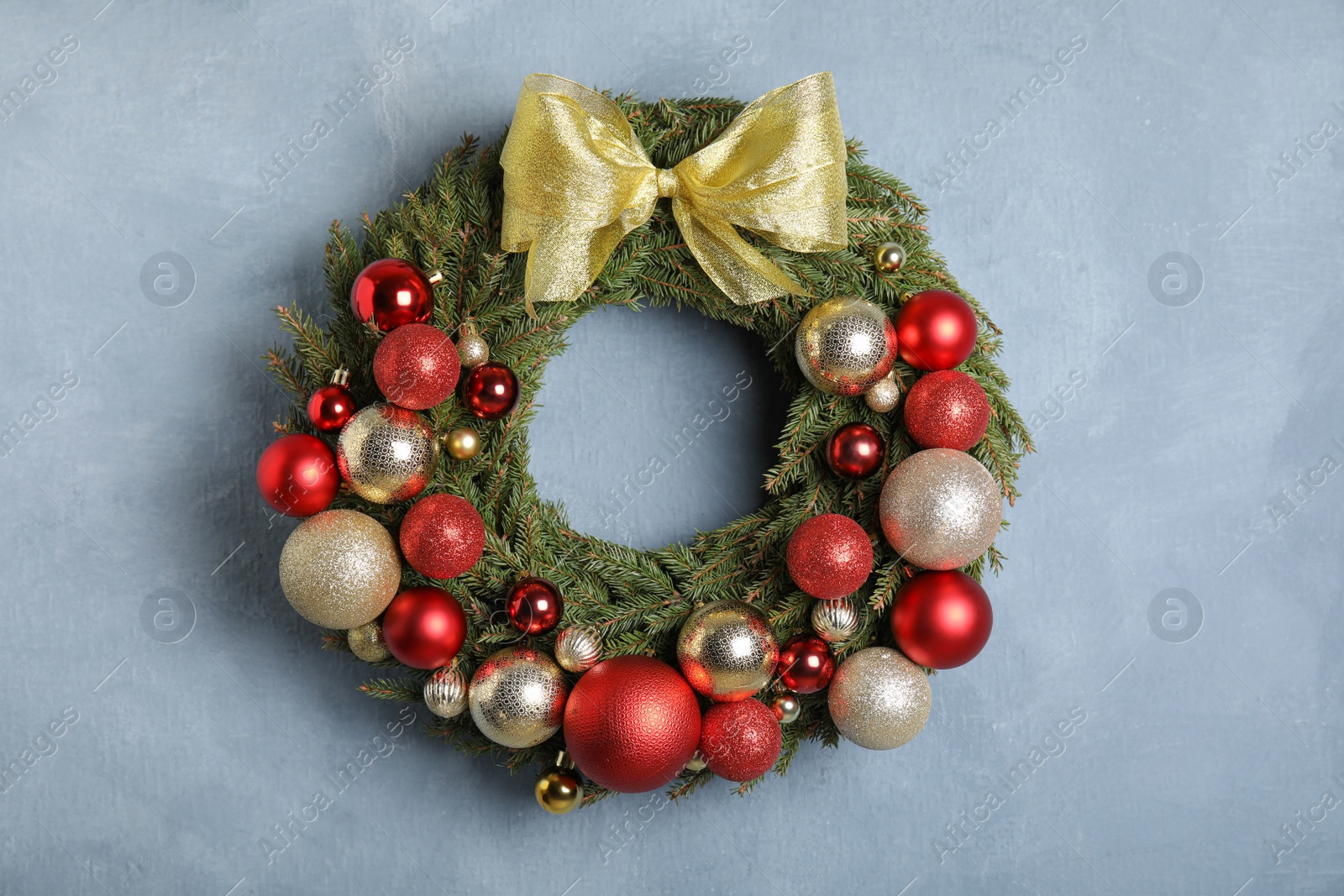 Photo of Beautiful Christmas wreath with festive decor on light blue background