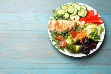 Photo of Balanced diet and healthy foods. Plate with different delicious products on light blue wooden table, top view. Space for text