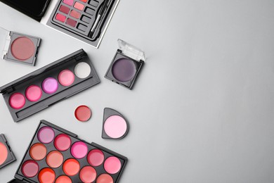 Photo of Flat lay composition with cream lipstick palettes on light grey background, space for text. Professional cosmetic product