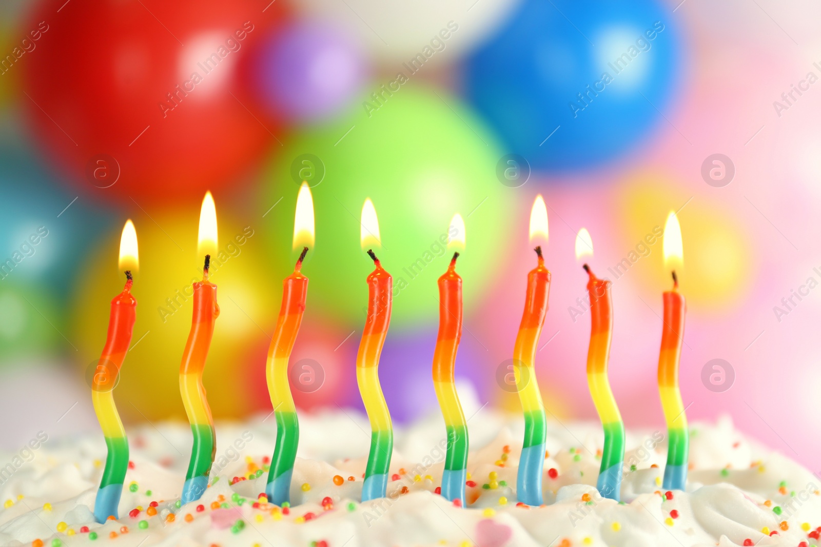 Photo of Birthday cake with burning candles on blurred background, closeup