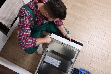 Serviceman examining dishwasher's door indoors, above view