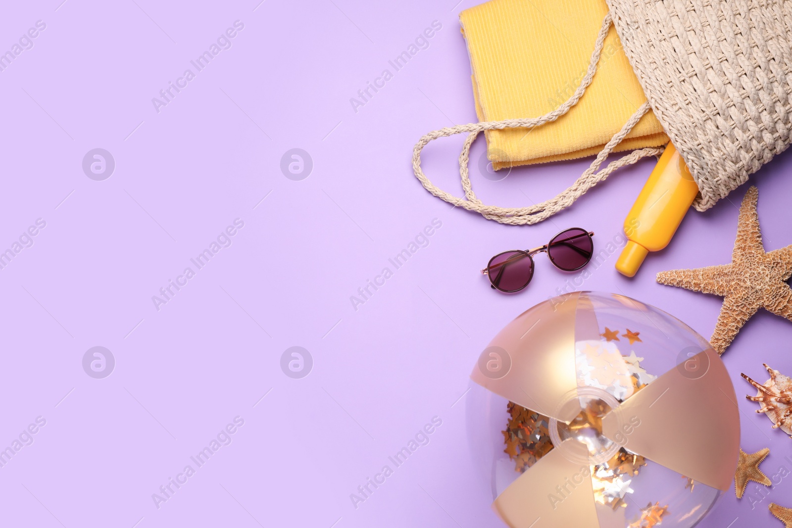 Photo of Flat lay composition with beach ball and other accessories on violet background. Space for text