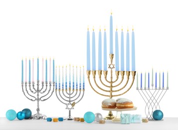 Photo of Hanukkah celebration. Composition with different menorahs, dreidels and gift boxes on table against white background