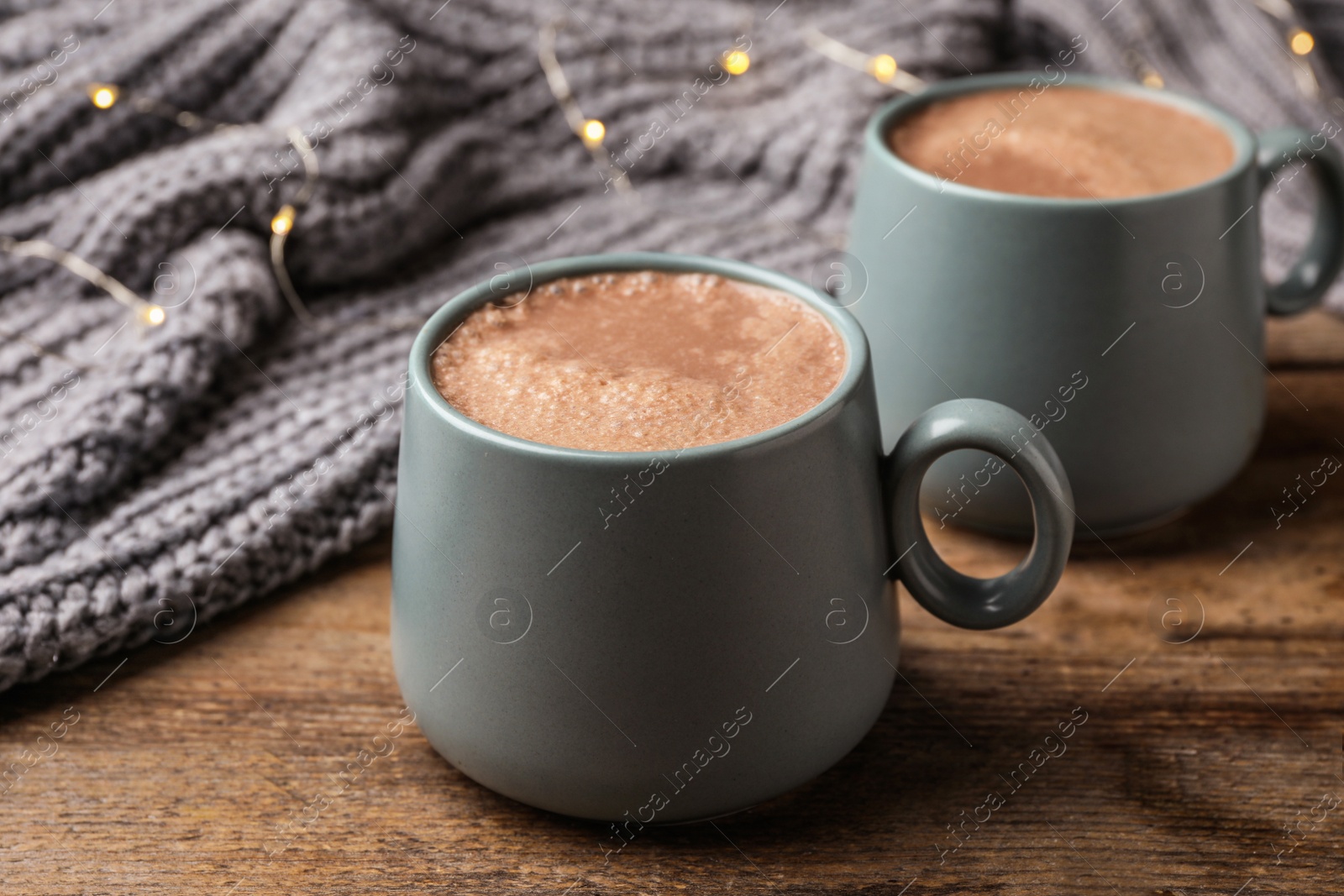 Photo of Cups of delicious hot cocoa on wooden table