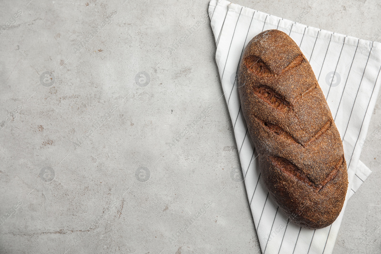 Photo of Fresh bread on grey table, top view. Space for text