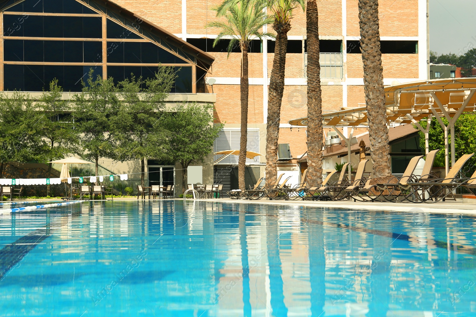 Photo of Swimming pool and sunbeds at luxury resort