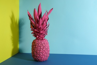 Pink pineapple on color background, space for text. Creative concept