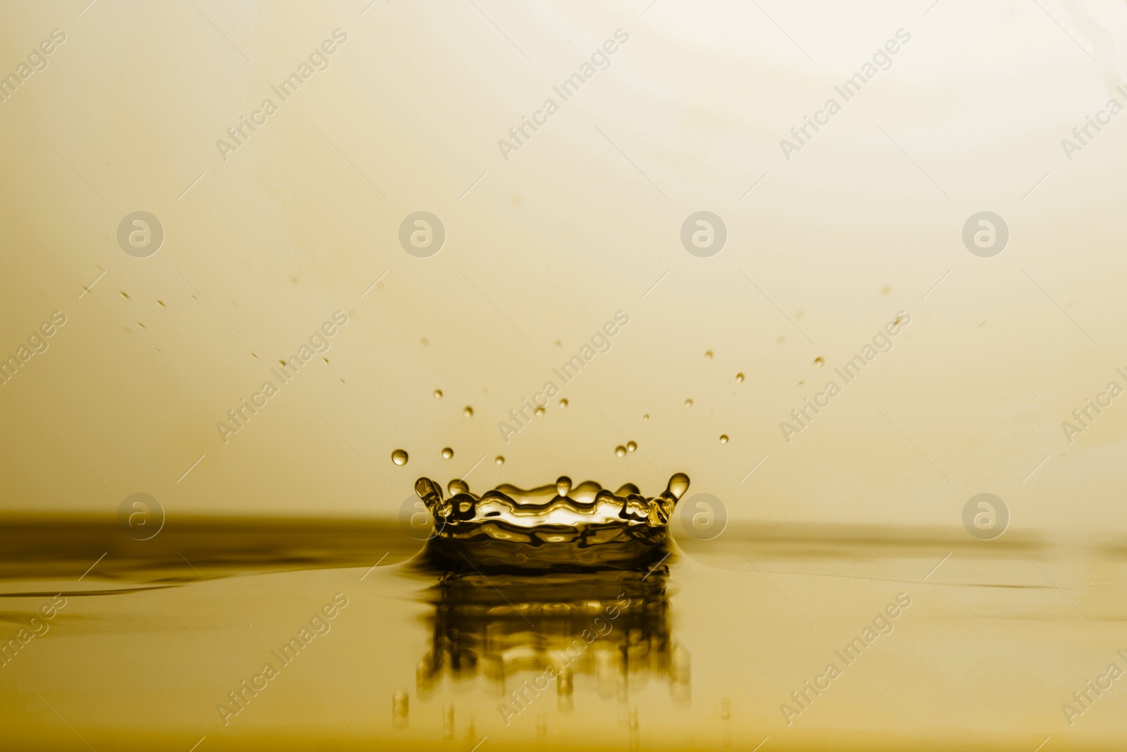 Image of Splash of golden oily liquid with drops as background, closeup