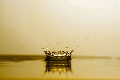 Image of Splash of golden oily liquid with drops as background, closeup