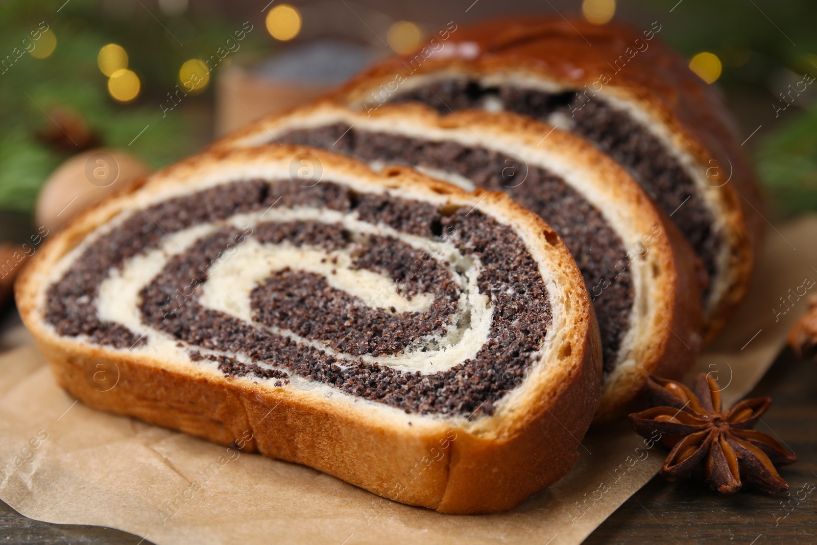 Photo of Slices of poppy seed roll and anise star on table, closeup. Tasty cake