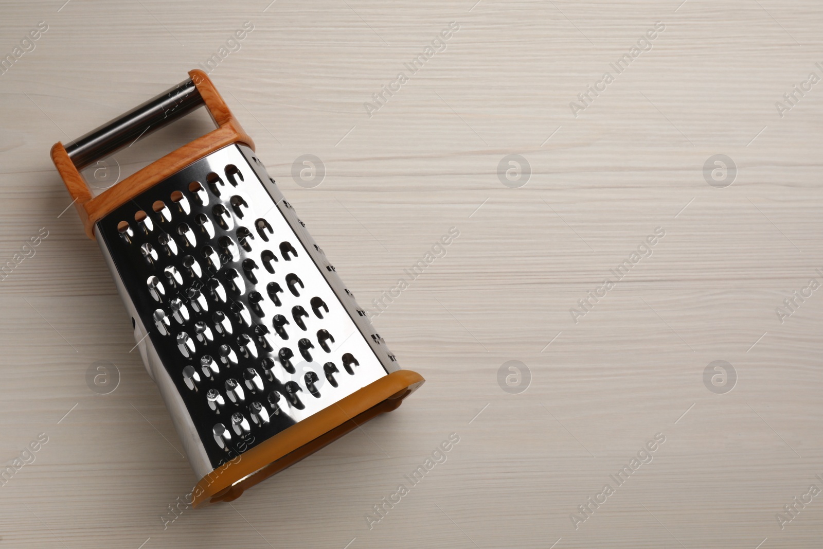 Photo of Modern grater on white wooden table, top view. Space for text