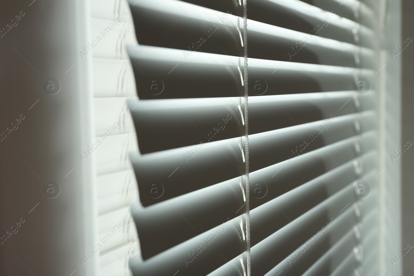 Photo of Closed modern white window blinds, closeup view