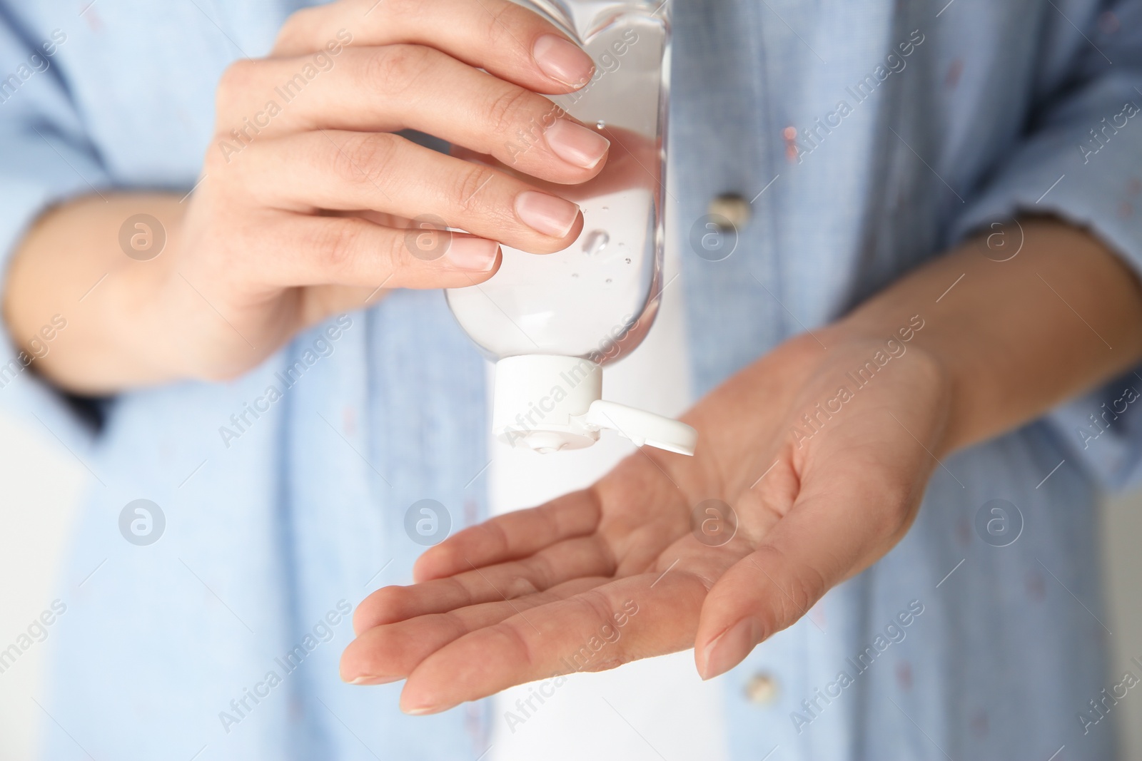 Photo of Woman applying antiseptic gel on hand, closeup