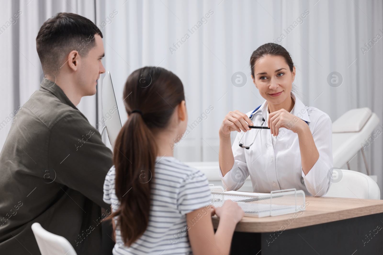 Photo of Gastroenterologist consulting man and his daughter in clinic