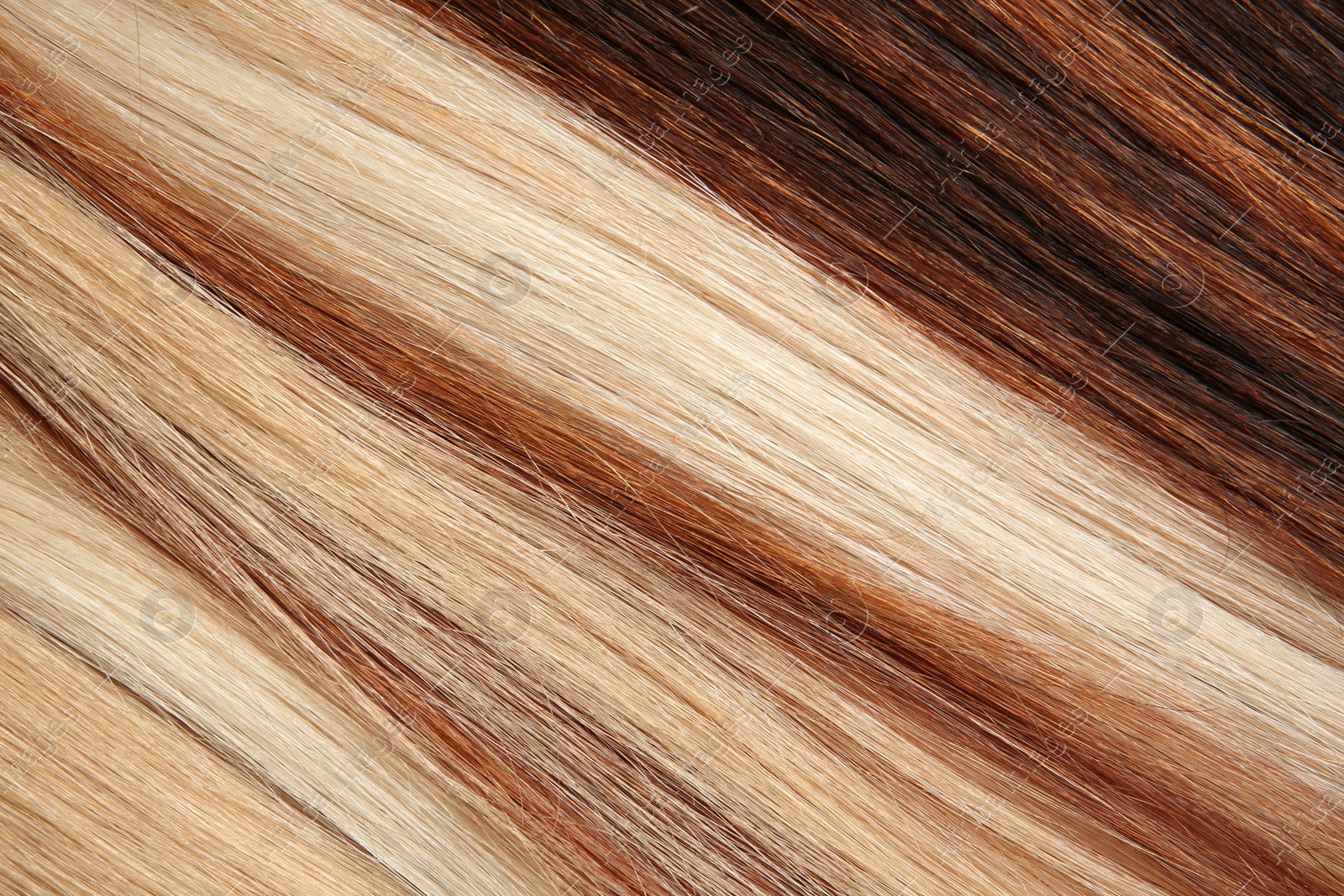 Photo of Strands of different color hair as background, closeup