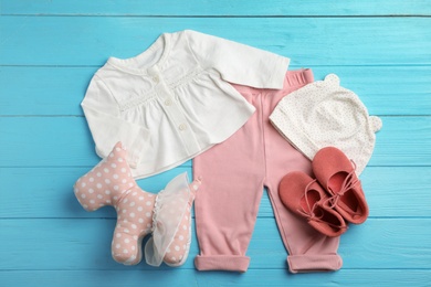 Flat lay composition with cute clothes on wooden background. Baby accessories