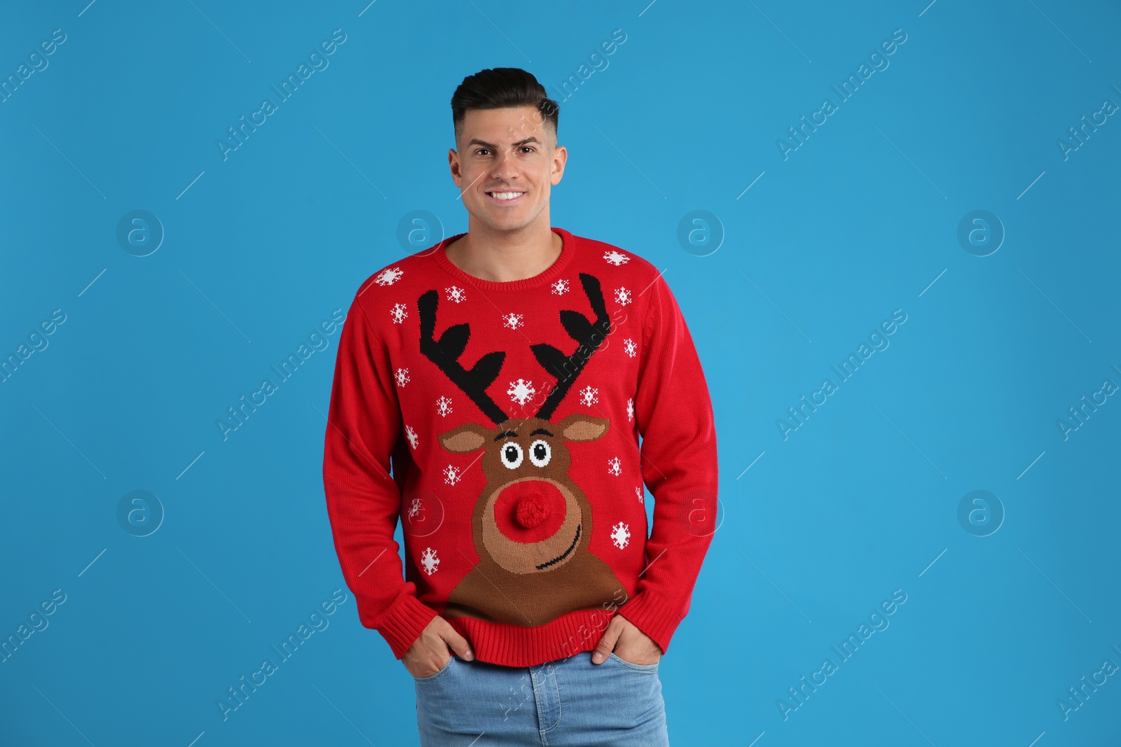 Photo of Handsome man in Christmas sweater on blue background