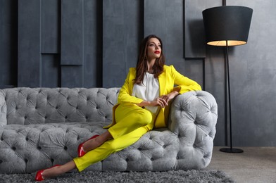 Photo of Beautiful businesswoman on sofa indoors. Luxury lifestyle