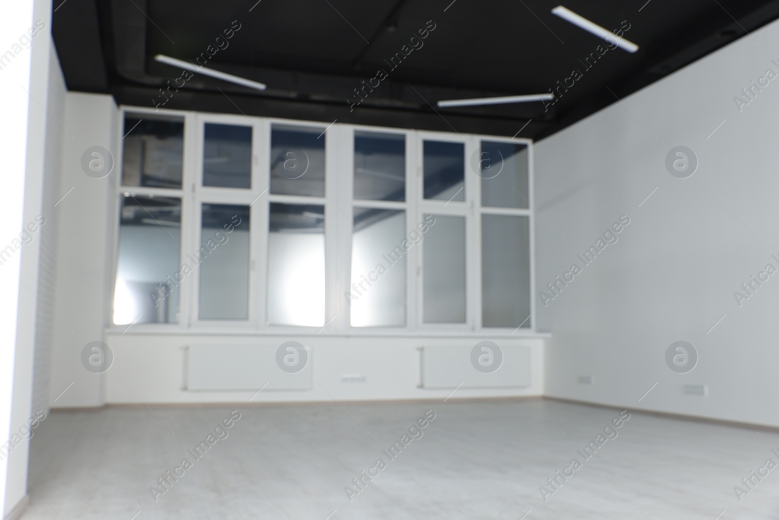 Photo of Empty office room with black ceiling and clean windows. Interior design