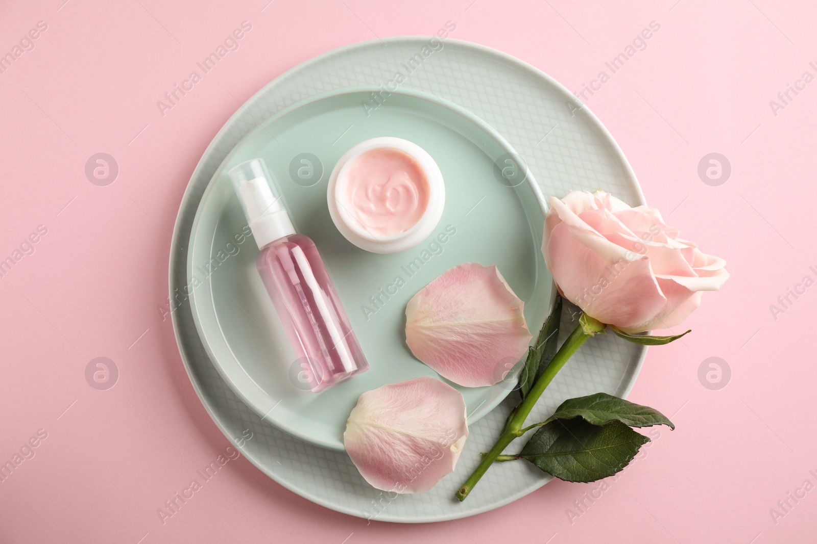 Photo of Flat lay composition with rose essential oil on pink background