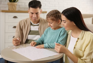 Happy family playing with puzzles at home