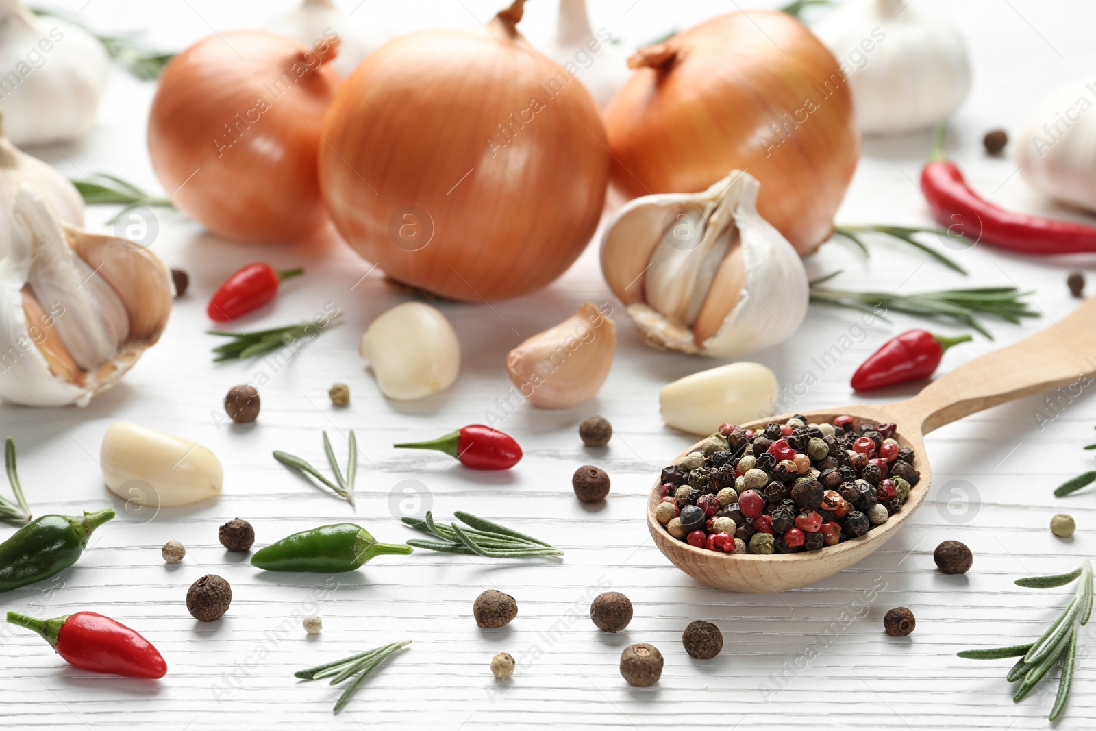 Photo of Composition with garlic, onions and pepper on white wooden background