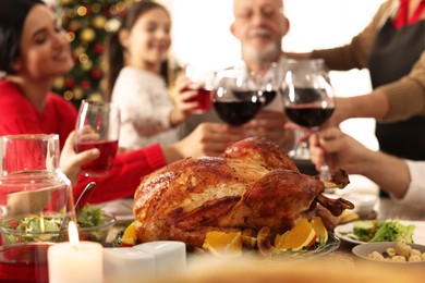 Photo of Family enjoying festive dinner at home, focus on delicious baked turkey. Christmas celebration