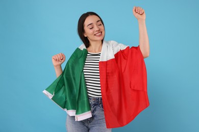 Photo of Young woman with flag of Italy on light blue background