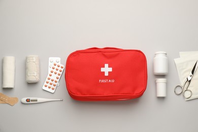 Photo of Flat lay composition with first aid kit on light grey background