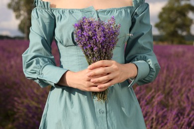 Woman with bouquet of lavender outdoors, closeup