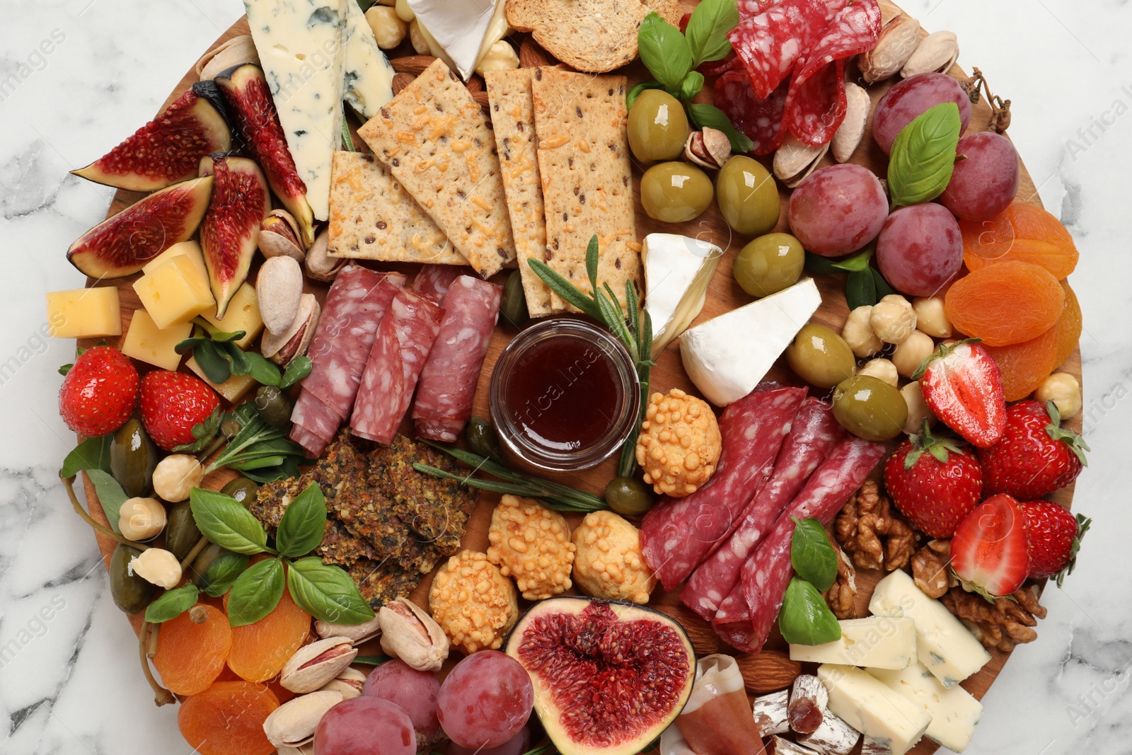 Photo of Different tasty appetizers on white marble table, top view