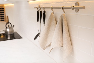 Photo of Kitchen utensils and clean towels hanging on wall indoors